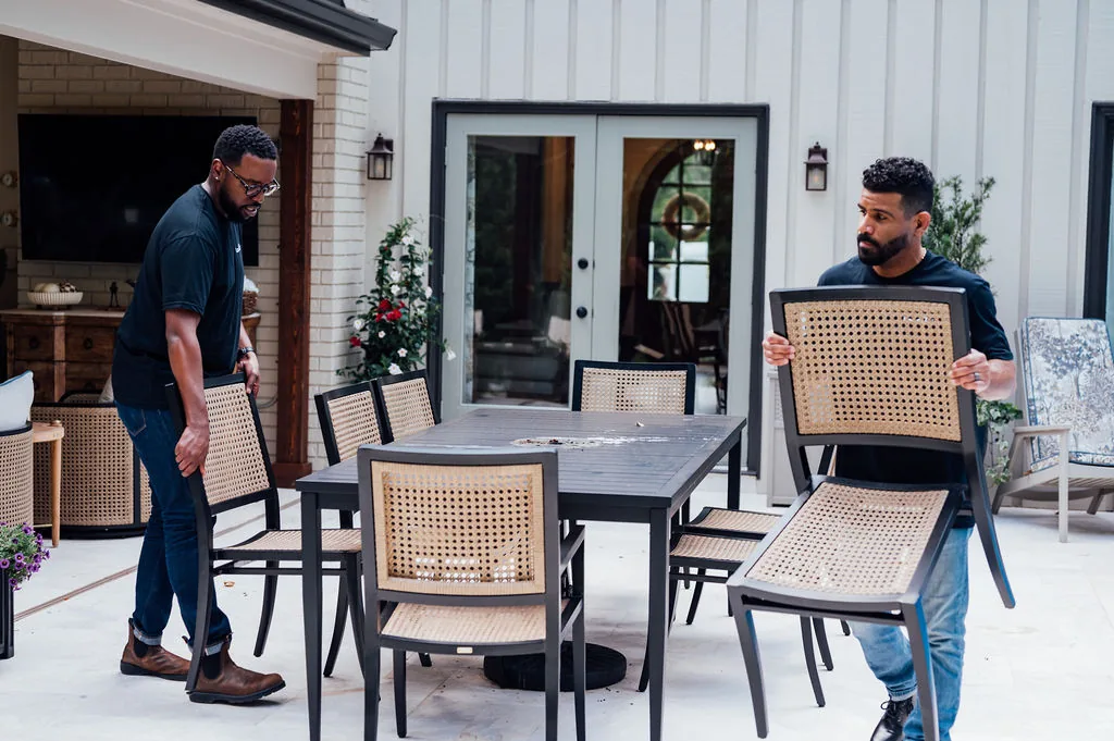 Two LoadUp Loaders removing a dining table and cane-back chairs from a patio