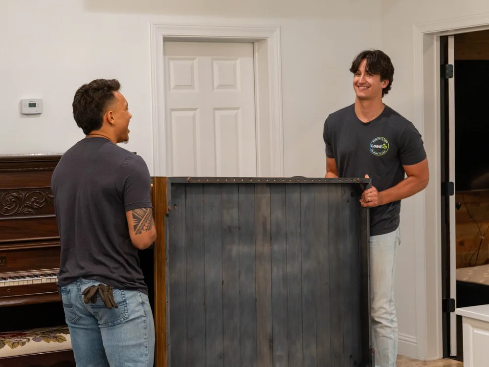 Two Furniture Disposal Plus Loaders carrying furniture out to a truck