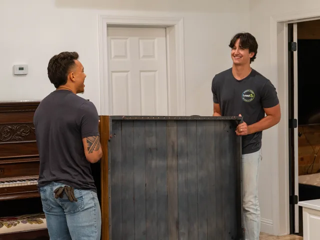 Two Furniture Disposal Plus Loaders carrying furniture out to a truck