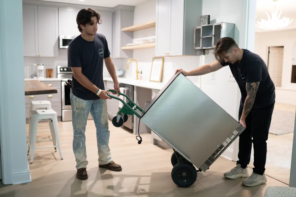 Furniture Disposal Plus Loaders removing a washing machine from a Miami home